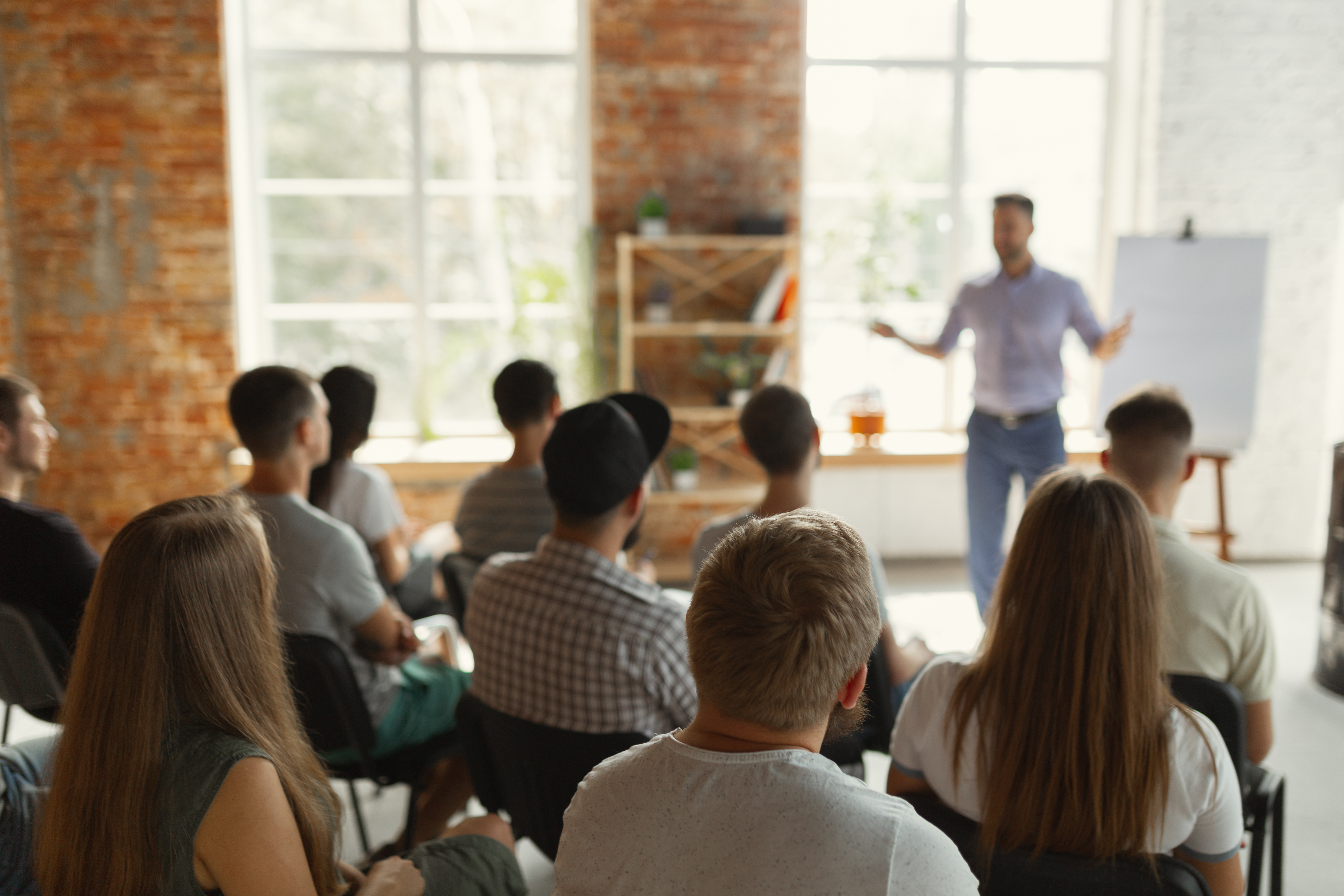 Presenter leading an AI workshop at a whiteboard with seated attendees